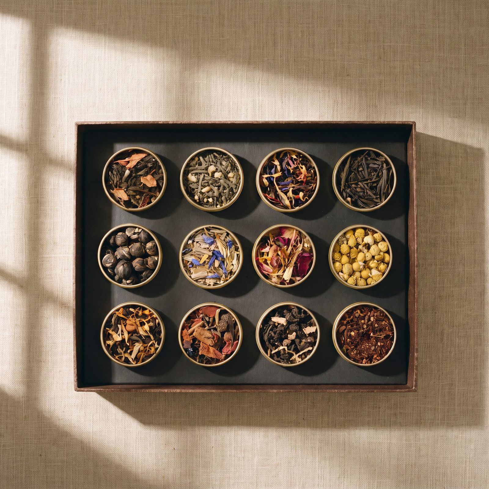 A Petite Box of twelve gold tins in window light